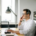 Confident salesperson making cold calls with a desktop calling, turning rejection into motivation.