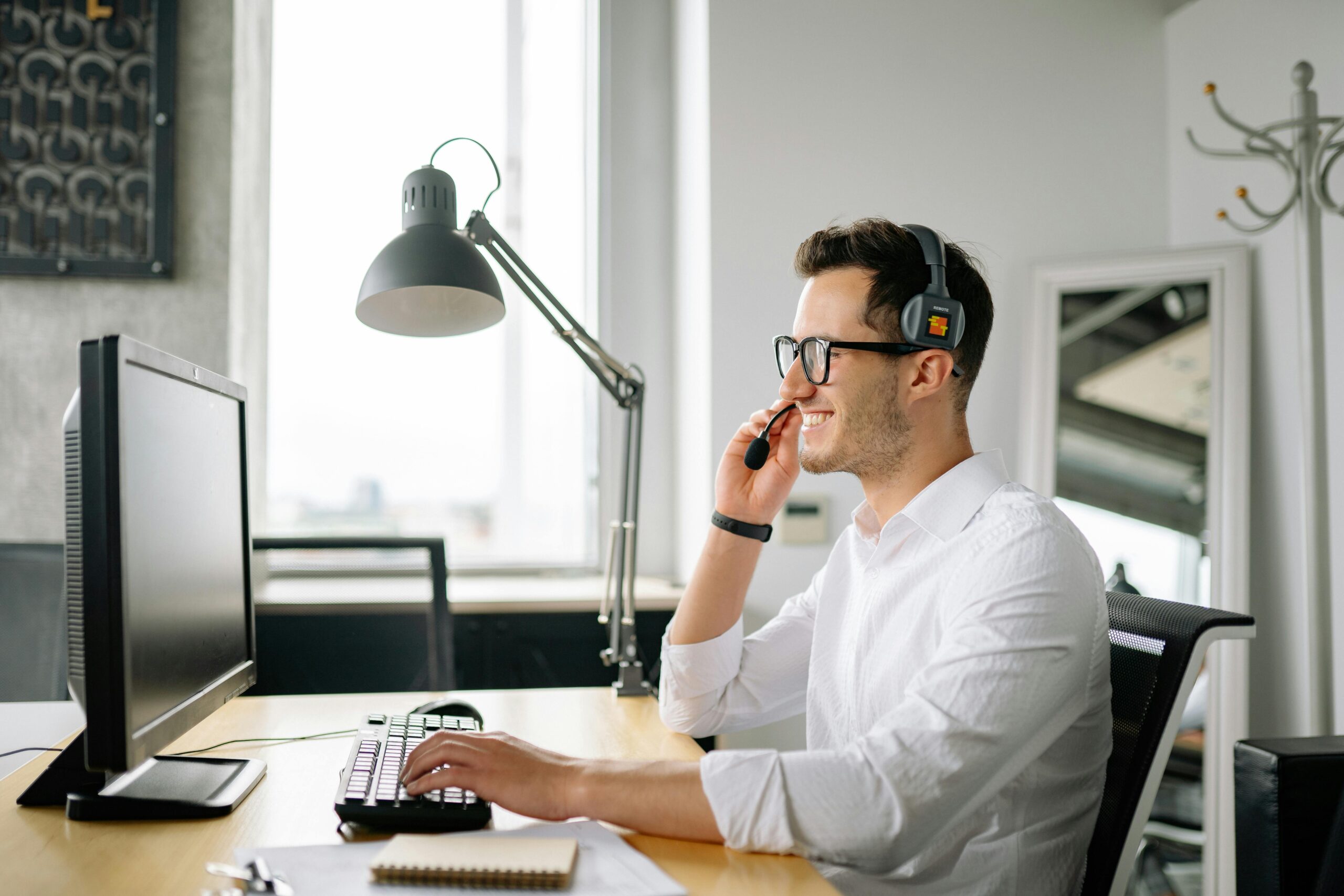 Confident salesperson making cold calls with a desktop calling, turning rejection into motivation.